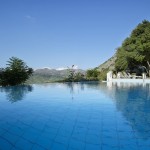 A large infinity swimming pool with a spacious sun deck at Country Hotel Velani in Greece, Crete.